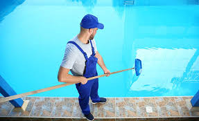 Image of a man brushing the pool